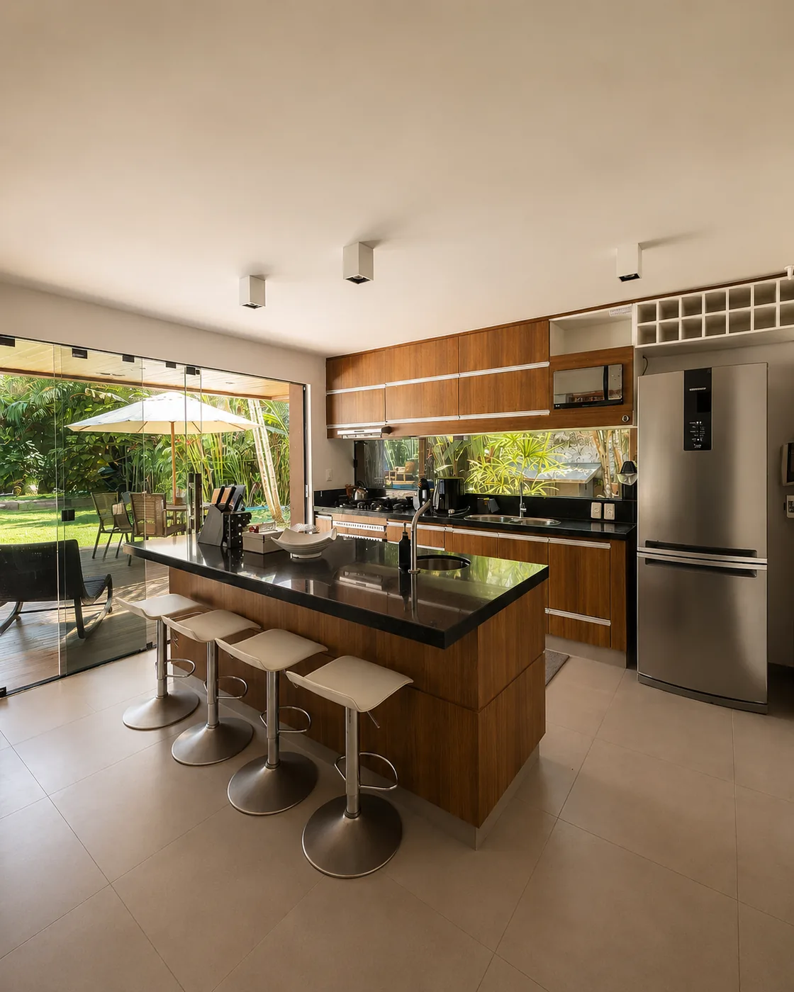 Cozinha completa da Casa Paraíso com ilha e janela ampla para o jardim