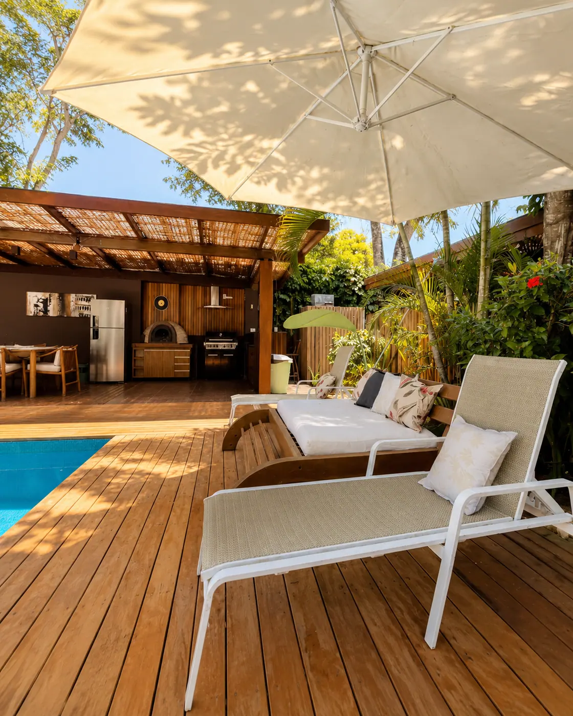 Deck with a pergola and sun loungers beside the Casa Paraíso private pool
