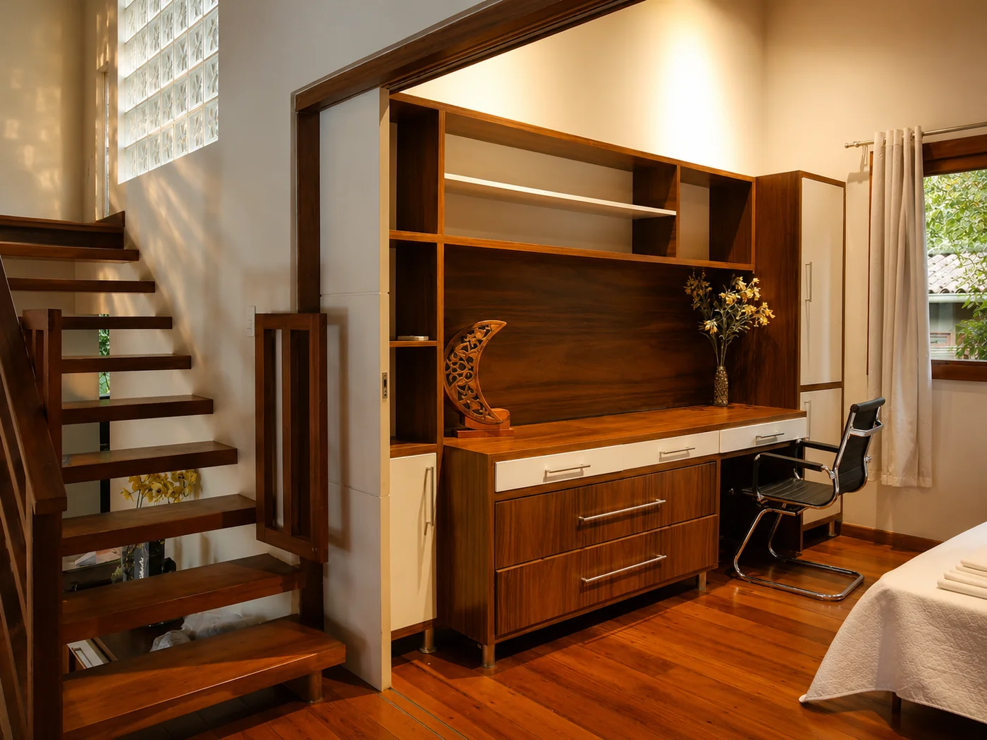Espacio de trabajo de Casa Paraíso en la suite, con escritorio de madera empotrado y silla de oficina junto a la escalera