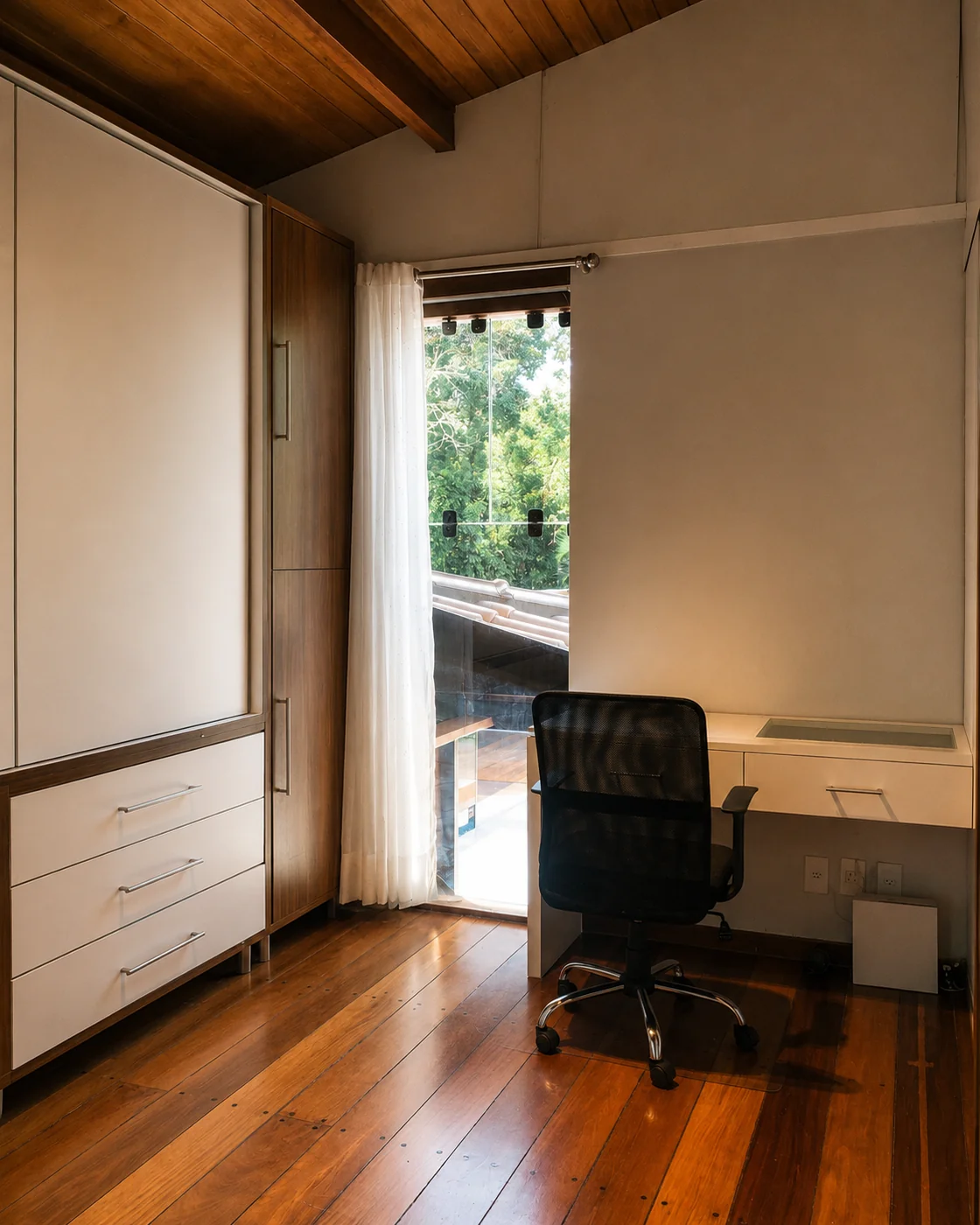 Espacio de trabajo en la suite de Casa Paraíso, con escritorio blanco, silla de oficina y puerta hacia el balcón