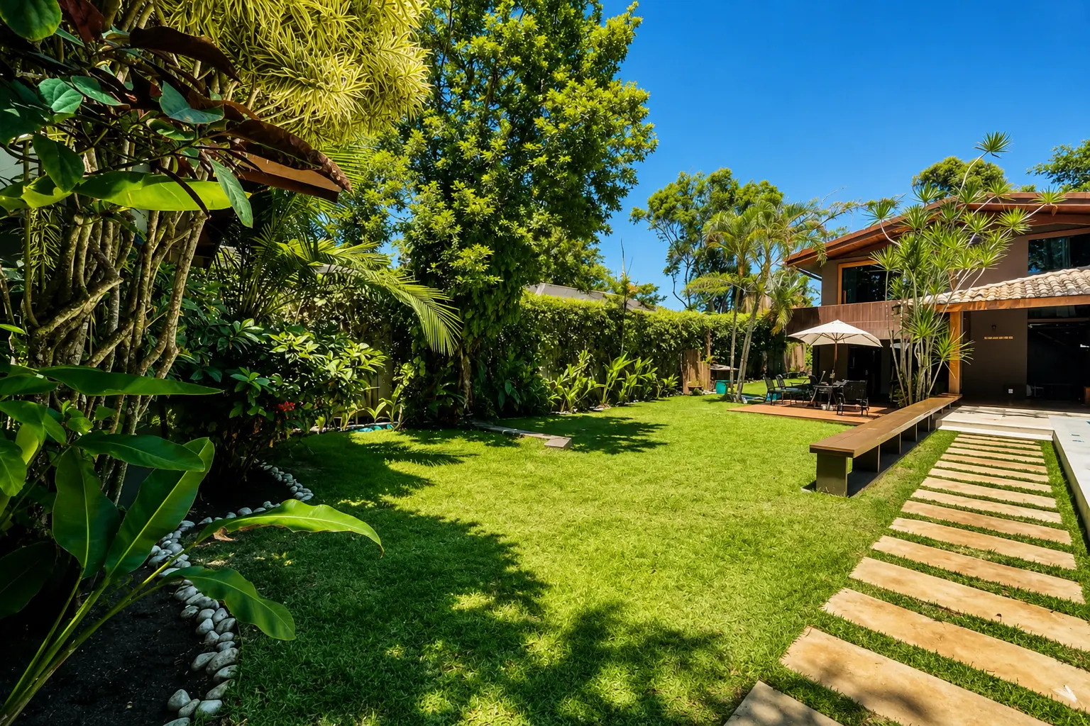 Amplo jardim gramado da Casa Paraíso com paisagismo maduro