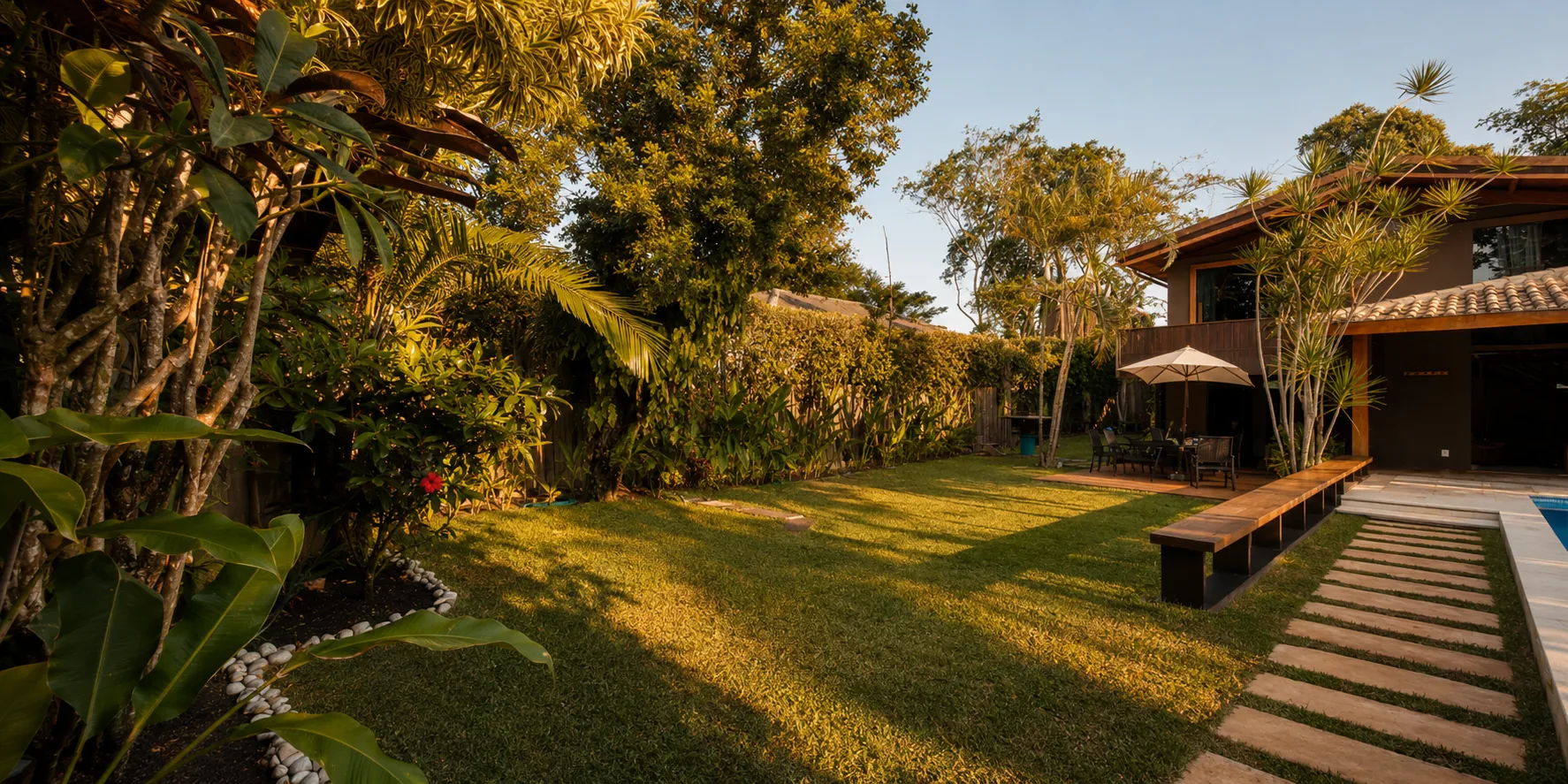 Panoramic view of the Casa Paraíso lawn, with the house and stone path in the background