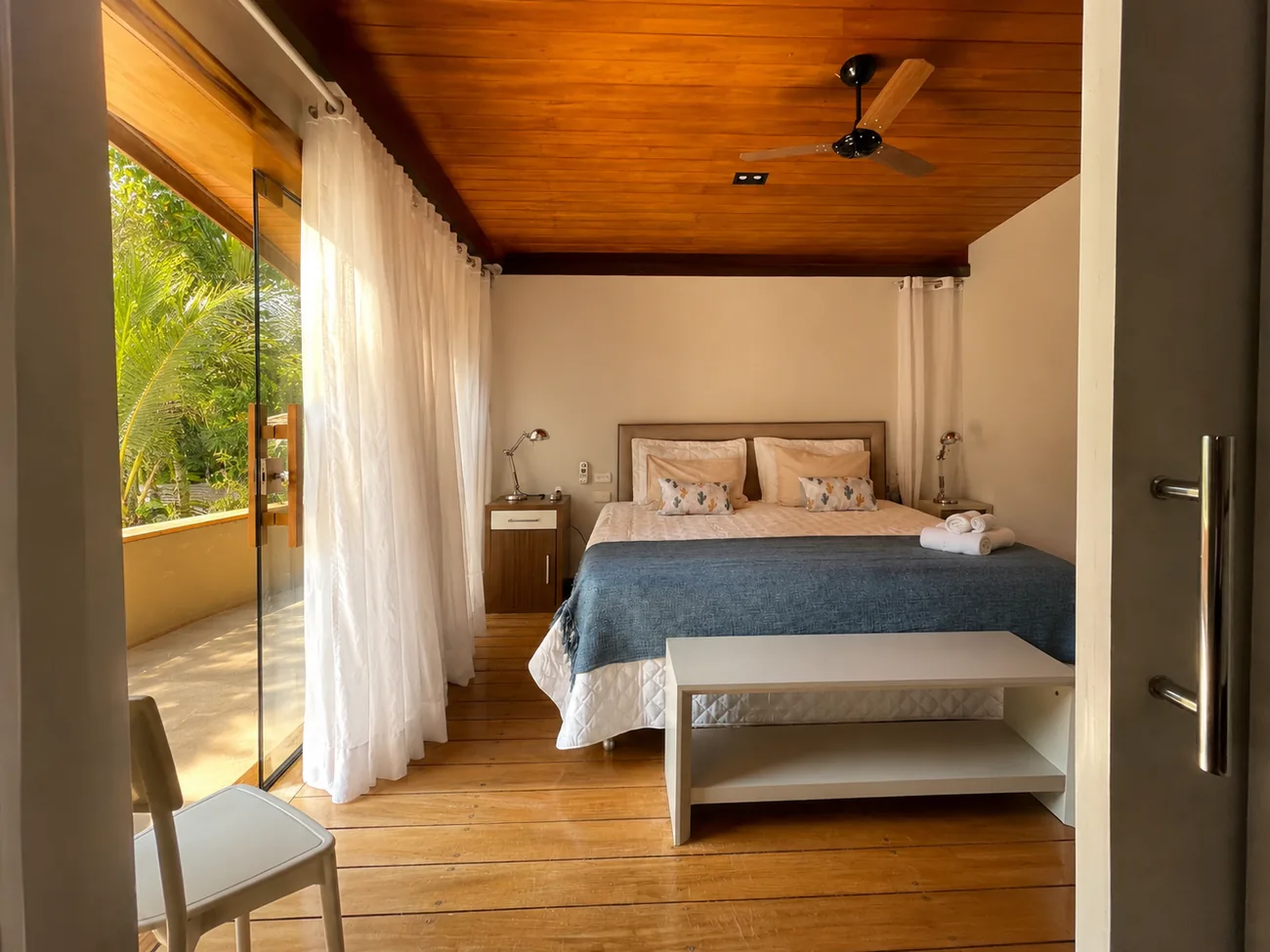 Quarto da Casa Paraíso com cama queen e cortinas leves
