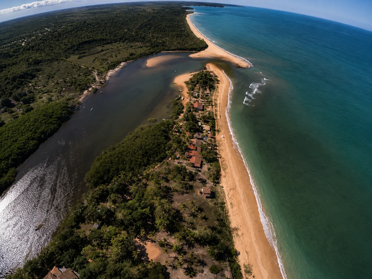 Barcos en el río de Caraíva, con el pueblo entre los cocoteros y el mar al fondo
