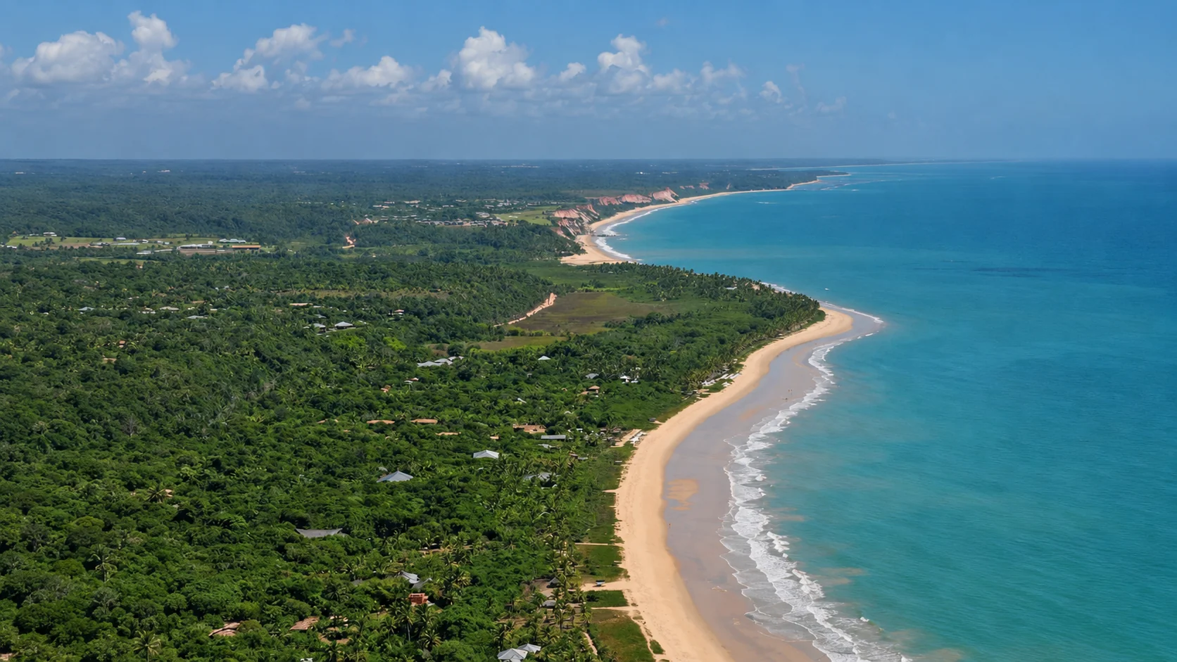 Aerial view of the Arraial d'Ajuda coast, with boats on the green-blue sea and houses among the palms