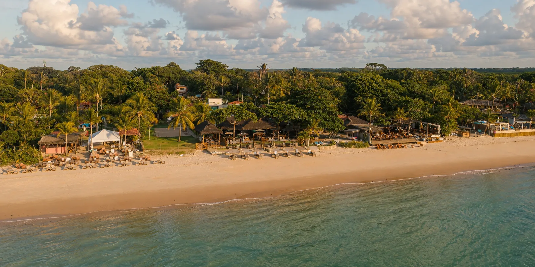 Aerial view of an Arraial d'Ajuda beach, with a strip of sand between the sea and Atlantic Forest